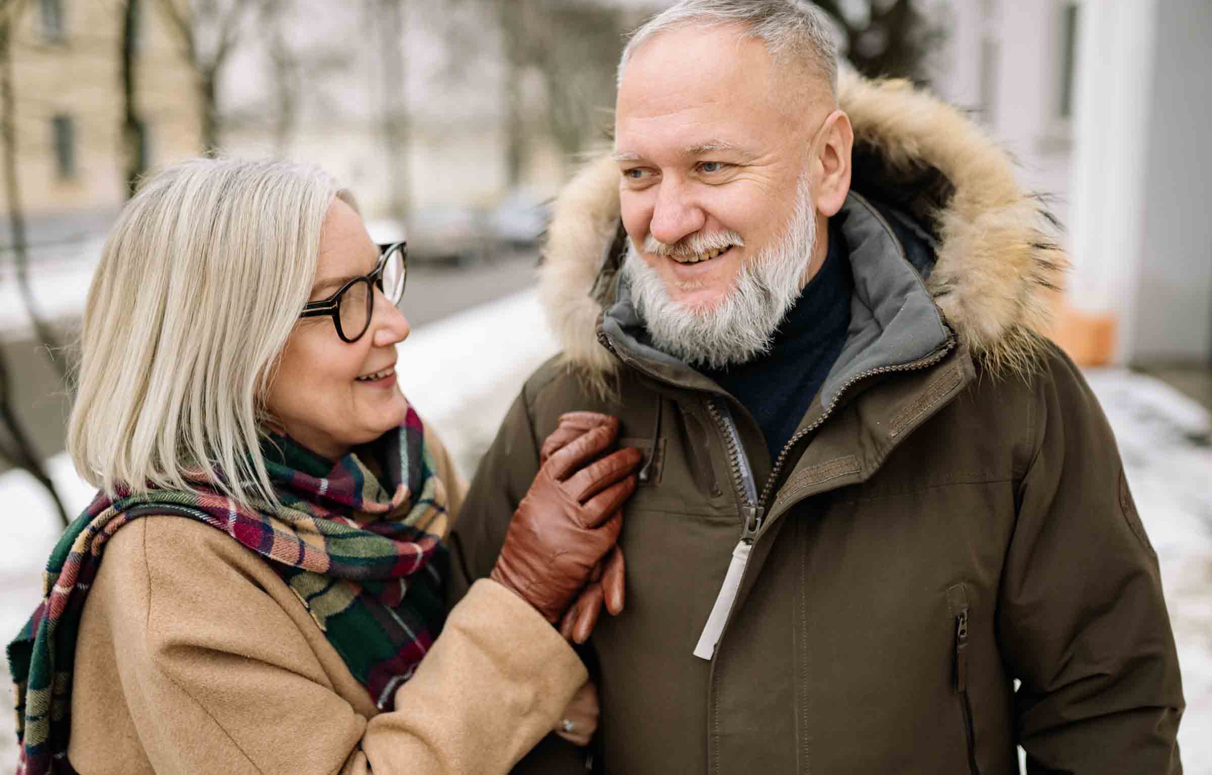 Adult couple in front of their co-op building in the middle of winter