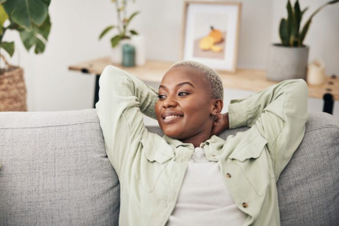 woman feeling accomplished while relaxing on hour couch