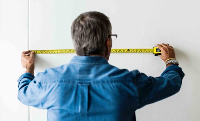 Man measuring wall in his condo